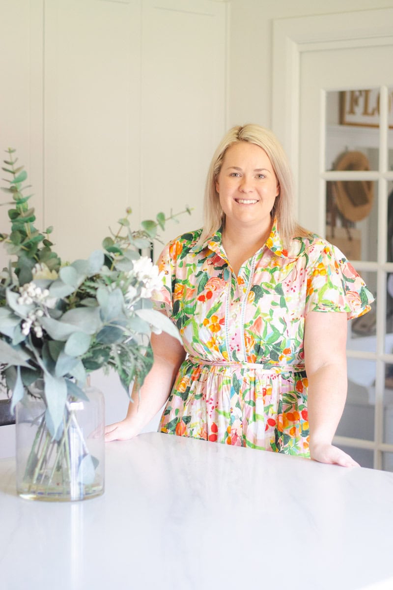 A picture of a woman (Carla) standing in her kitchen.